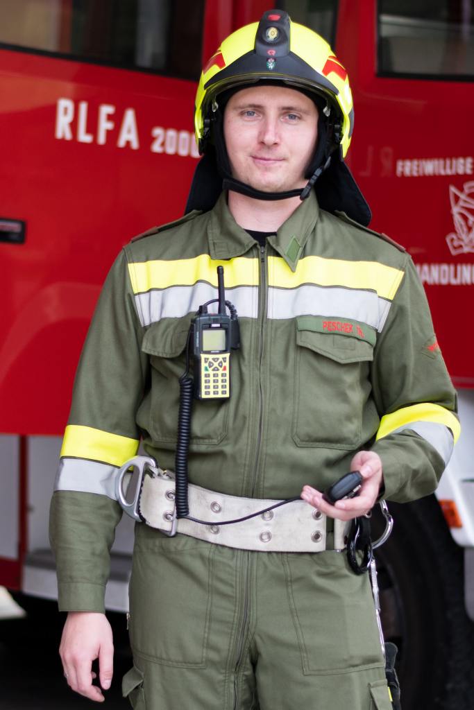 Thomas Peschek in Feuerwehruniform mit dem Funkgerät in der Hand